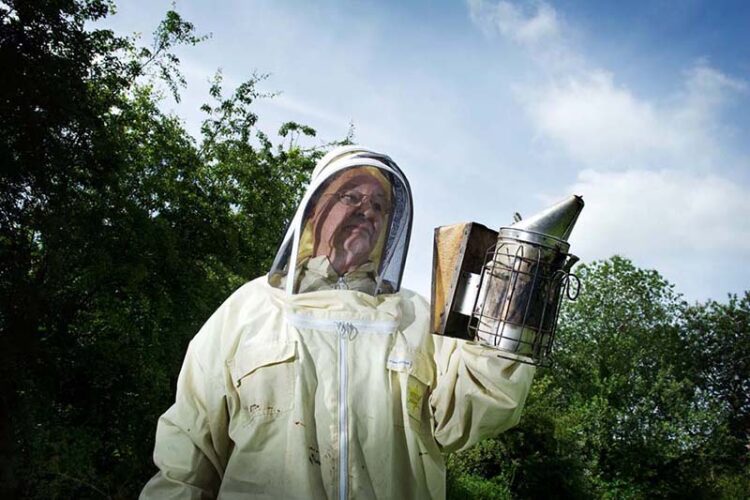 Bob Spruce holding the smoker, ready to inspect his hives
